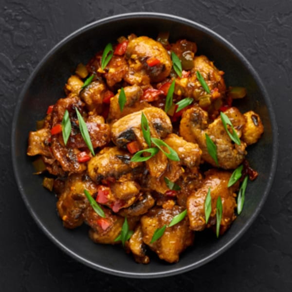 Namaste Express's chili mushroom dish, featuring mushrooms, peppers, and green onions in a rich sauce.